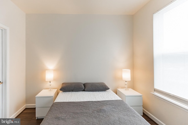 bedroom with dark hardwood / wood-style floors