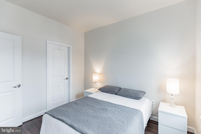 bedroom with dark hardwood / wood-style flooring