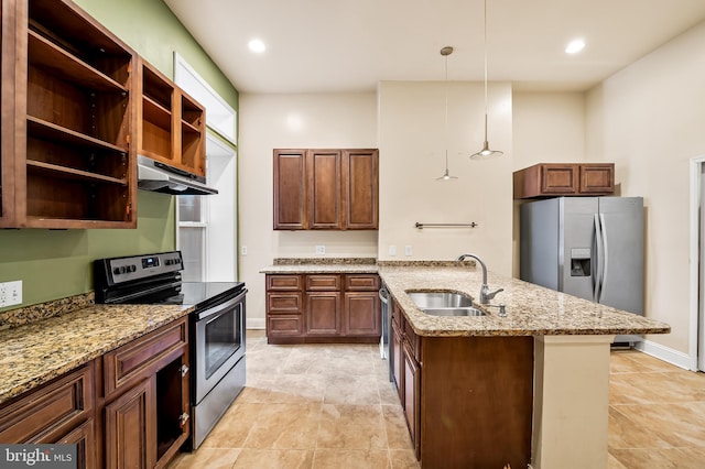 kitchen with light stone countertops, appliances with stainless steel finishes, decorative light fixtures, an island with sink, and sink