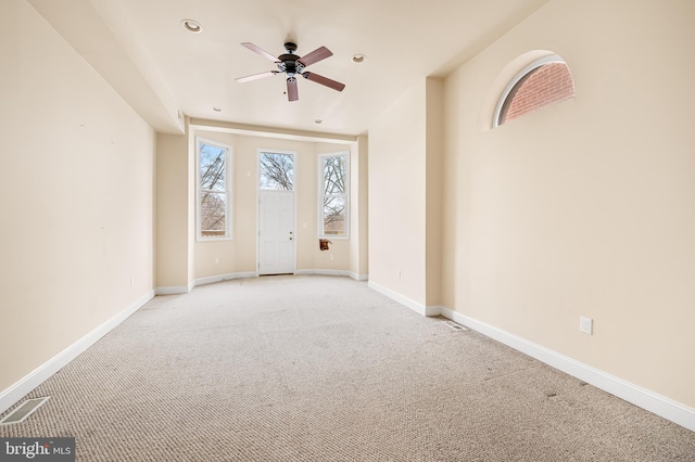 spare room featuring light carpet and ceiling fan