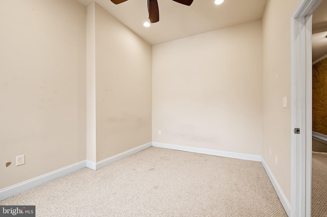 carpeted spare room featuring ceiling fan