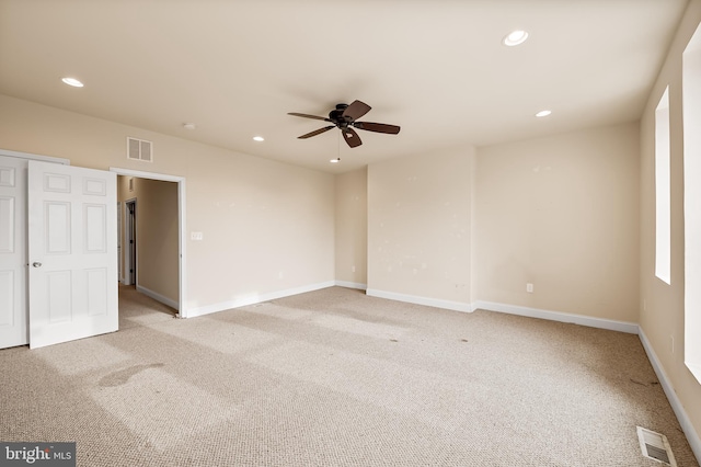 empty room featuring ceiling fan and light colored carpet