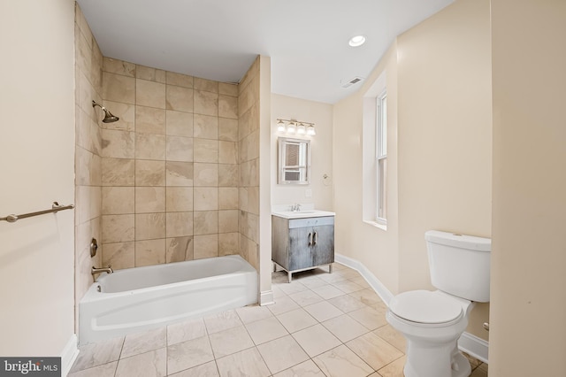 full bathroom with toilet, vanity, and tiled shower / bath