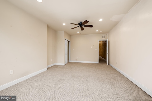 carpeted spare room featuring ceiling fan