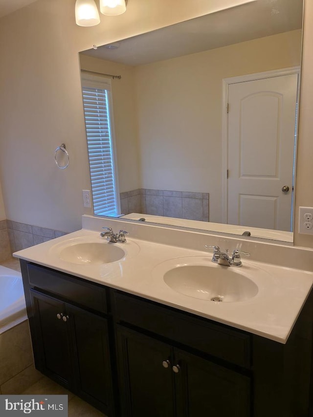 bathroom featuring a relaxing tiled tub, tile patterned flooring, and vanity