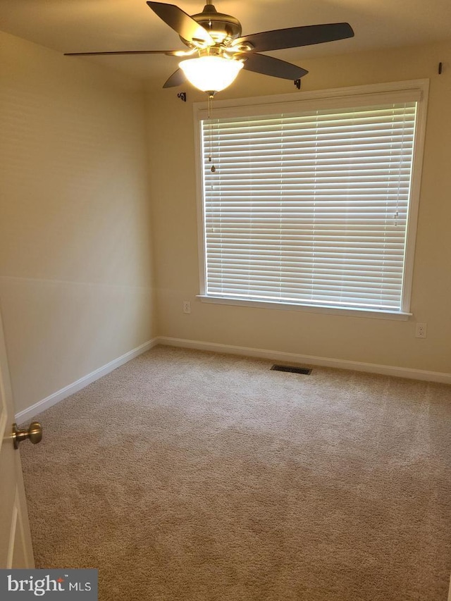 carpeted spare room featuring ceiling fan