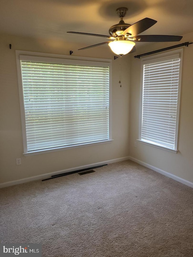 spare room with carpet flooring, ceiling fan, and a healthy amount of sunlight