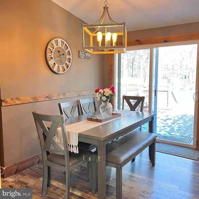 dining area with wood-type flooring and a chandelier