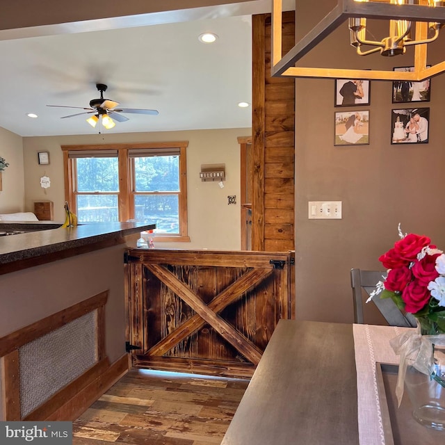 kitchen with ceiling fan with notable chandelier and wood-type flooring