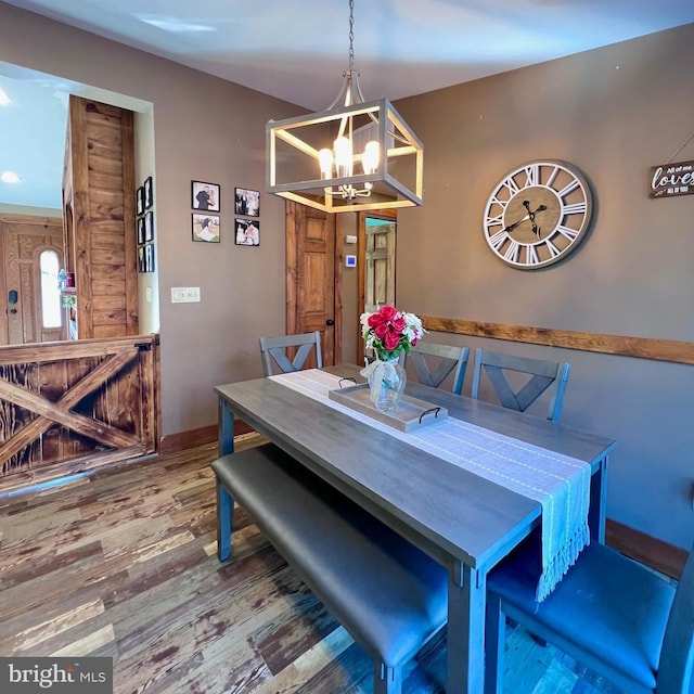 dining space with wood-type flooring and a chandelier