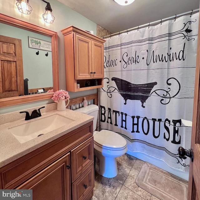 bathroom with walk in shower, vanity, and toilet