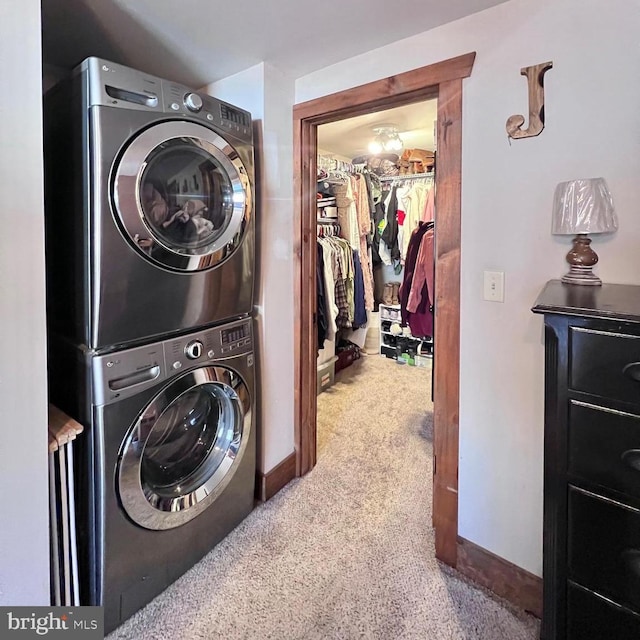 laundry area featuring stacked washing maching and dryer and carpet floors