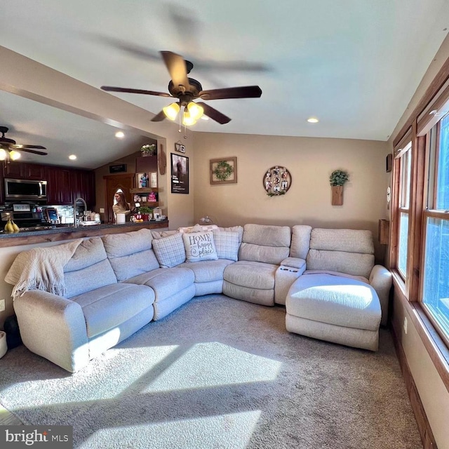 living room with carpet floors, ceiling fan, and vaulted ceiling