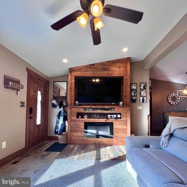 living room featuring lofted ceiling, ceiling fan, and carpet