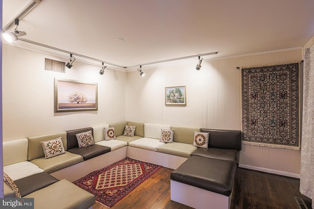 living room featuring dark wood-type flooring, crown molding, and track lighting