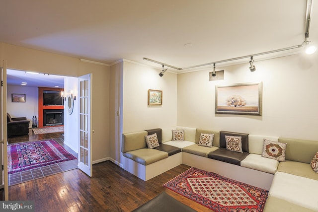 living room with track lighting, ornamental molding, and dark hardwood / wood-style flooring