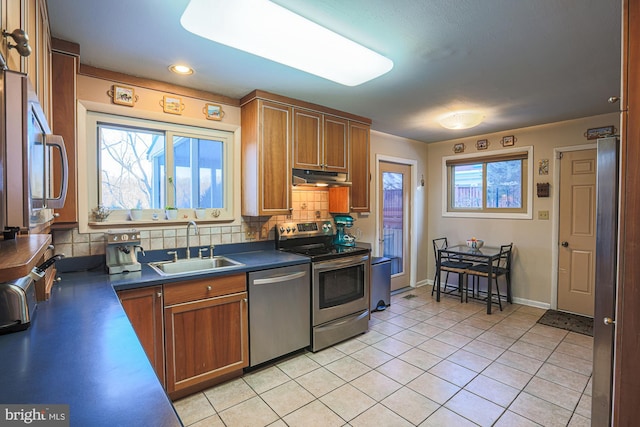 kitchen featuring tasteful backsplash, light tile patterned floors, sink, and stainless steel appliances