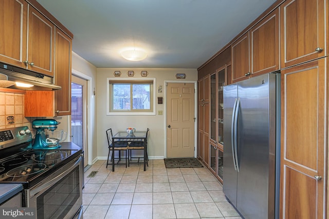 kitchen with light tile patterned floors, stainless steel appliances, and decorative backsplash