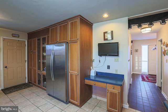 kitchen with light tile patterned floors and stainless steel fridge