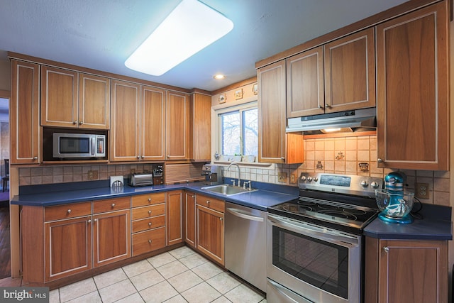 kitchen with sink, backsplash, stainless steel appliances, and light tile patterned flooring