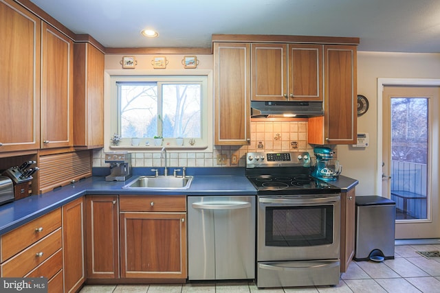 kitchen with tasteful backsplash, light tile patterned floors, sink, and stainless steel appliances