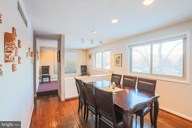 dining space featuring a textured ceiling and dark hardwood / wood-style floors