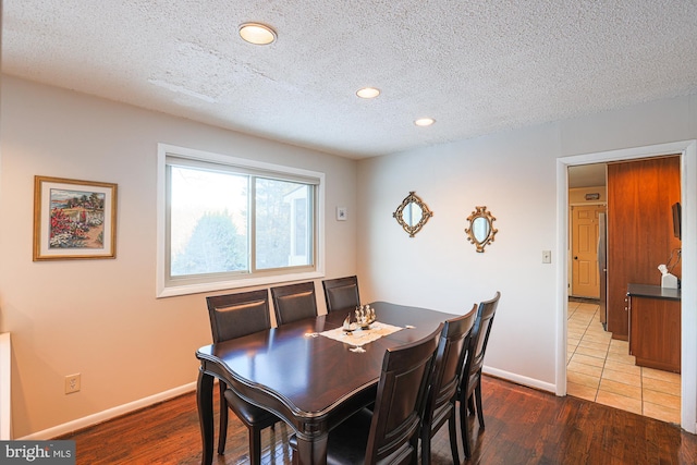 dining room featuring a textured ceiling and hardwood / wood-style floors