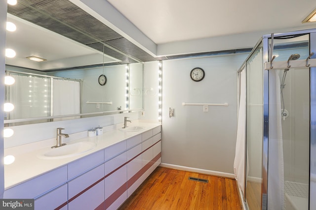 bathroom featuring hardwood / wood-style flooring, walk in shower, and vanity