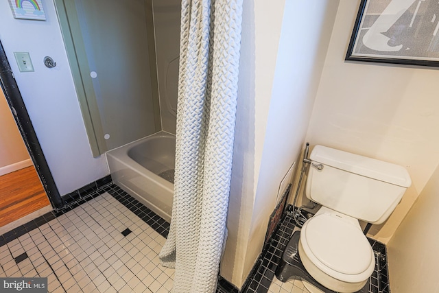 bathroom featuring toilet, shower / bath combination with curtain, and tile patterned floors