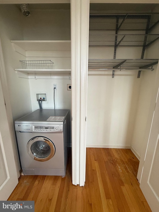 laundry area featuring laundry area, light wood finished floors, and washer / dryer