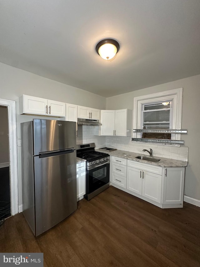 kitchen featuring dark wood-type flooring, appliances with stainless steel finishes, light stone countertops, and white cabinetry