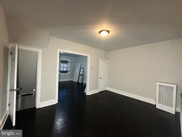 unfurnished room with dark hardwood / wood-style flooring