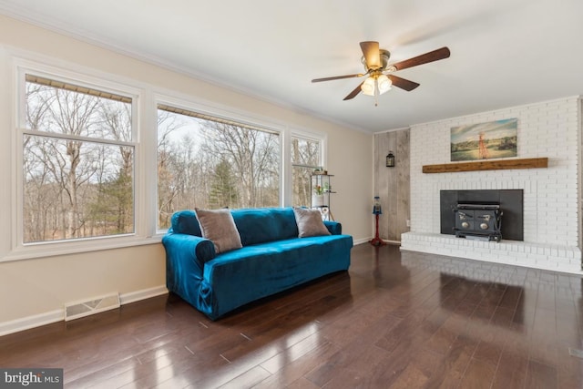 sitting room with visible vents, crown molding, baseboards, and wood finished floors