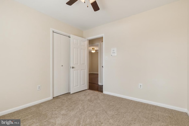 unfurnished bedroom with carpet, a closet, ceiling fan, and baseboards