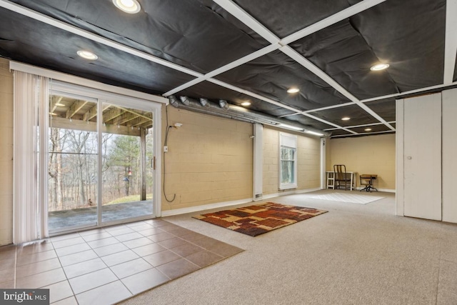 interior space featuring carpet, concrete block wall, and recessed lighting