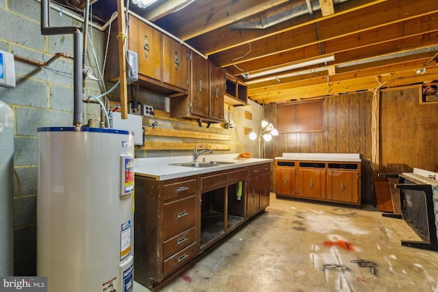 unfinished below grade area with water heater, a sink, and concrete block wall