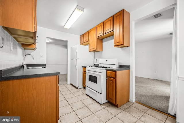 kitchen featuring sink, white appliances, and light colored carpet