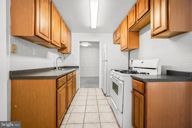 kitchen with sink, white appliances, and light tile patterned floors