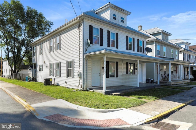 view of property featuring a front yard, a porch, and central air condition unit