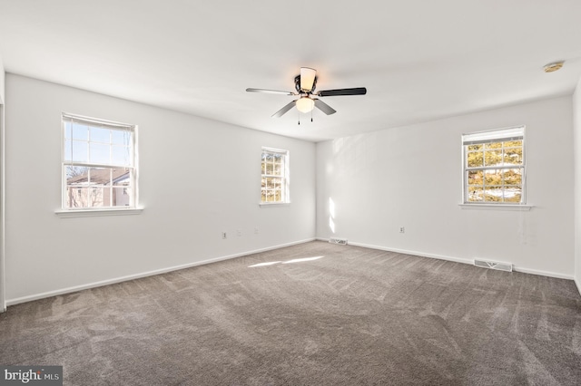 spare room with ceiling fan, carpet, and a wealth of natural light