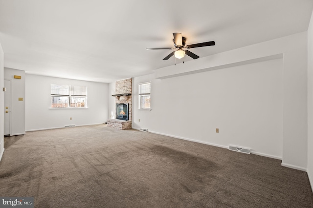 unfurnished living room featuring carpet floors, a fireplace, a wealth of natural light, and ceiling fan