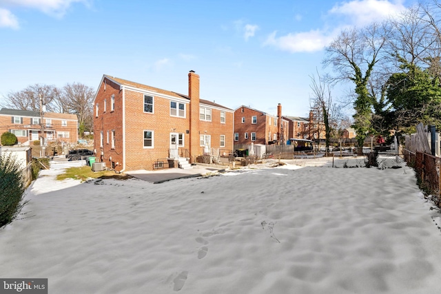 snow covered property with central air condition unit