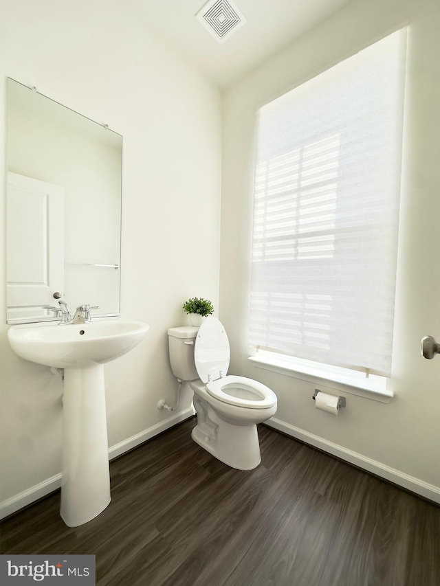 bathroom featuring toilet, wood-type flooring, and sink