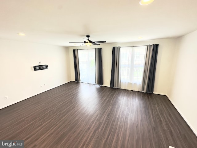 empty room with dark wood-type flooring and ceiling fan