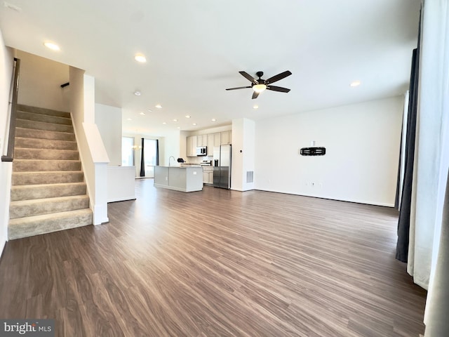 unfurnished living room with ceiling fan and dark hardwood / wood-style flooring