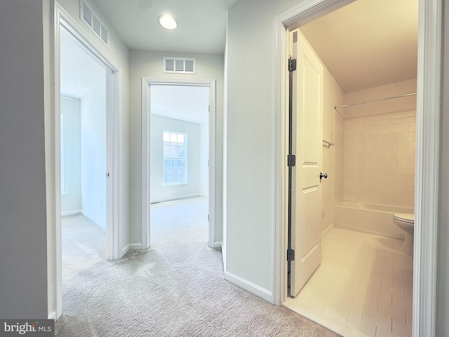 hallway featuring light colored carpet