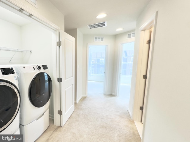 laundry room featuring washing machine and clothes dryer and light carpet