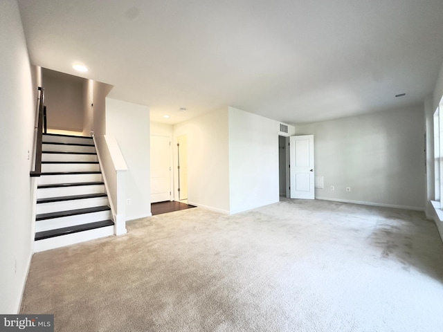 unfurnished living room with light colored carpet