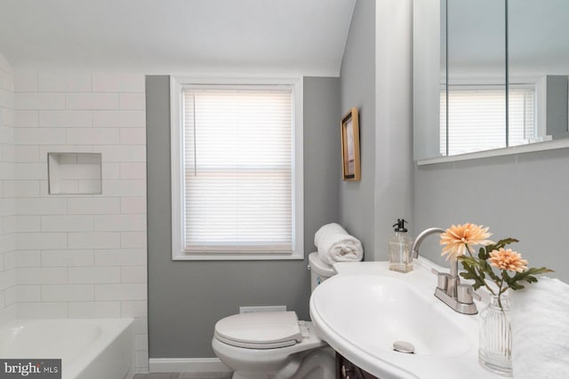 bathroom featuring sink, toilet, and a wealth of natural light