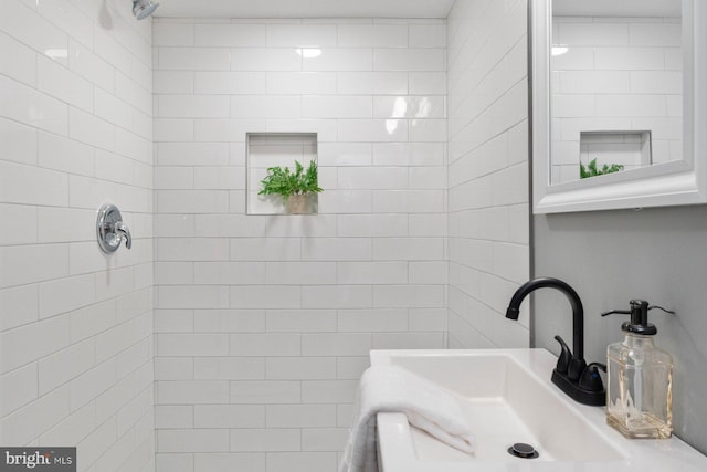 bathroom with sink and a tile shower